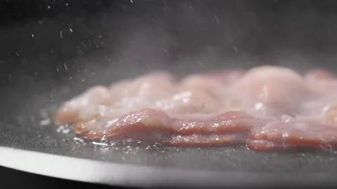 Crispy bacon sizzling in a pan, close-up shot. Stock Footage 317452097