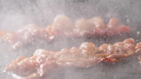 Crispy bacon sizzling in a pan, close-up shot. 動画素材 317452258