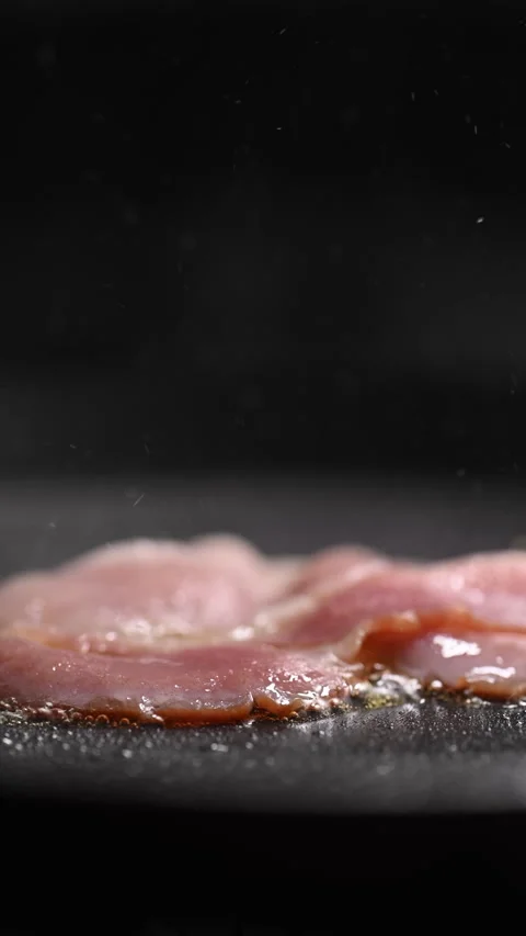 Crispy bacon sizzling in a pan, close-up shot. Vídeos de archivo 317452274