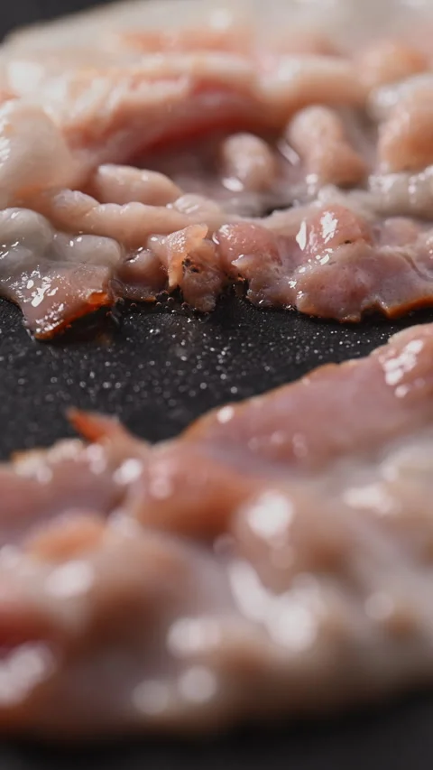Crispy bacon sizzling in a pan, close-up shot. Vídeos de archivo 317452377