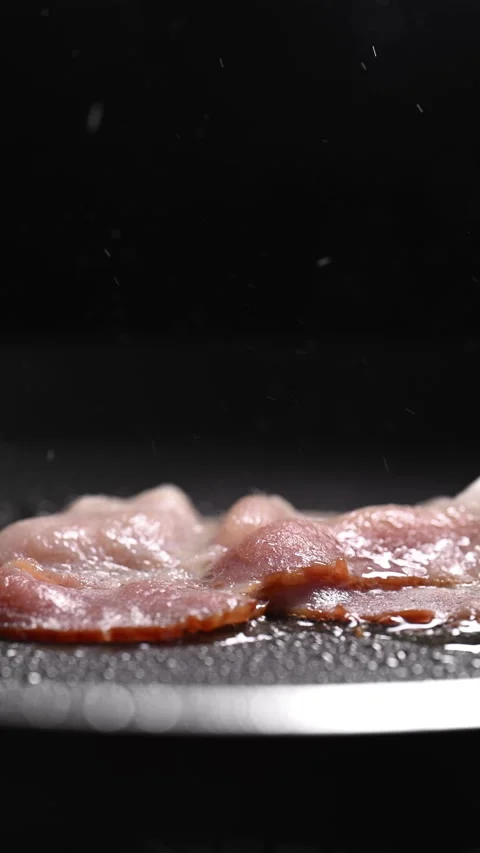 Crispy bacon sizzling in a pan, close-up shot. Vídeos de archivo 317452410