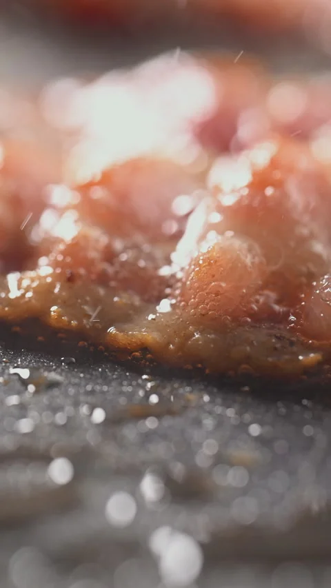 Crispy bacon sizzling in a pan, close-up shot. 動画素材 317452967