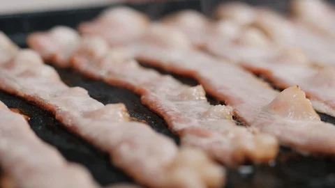 Crispy bacon strips are being fried on the stove Stock Footage 102655944