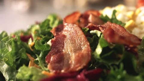 Crispy bacon strips bacon falling onto salad Video stock 120459769