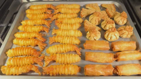 Crispy baked, battered snacks on a tray, hot from the oven. Stock Footage 296281159