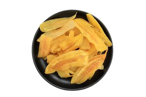 Crispy banana slice chips, fried or baked slice banana on black plate Stock Photos