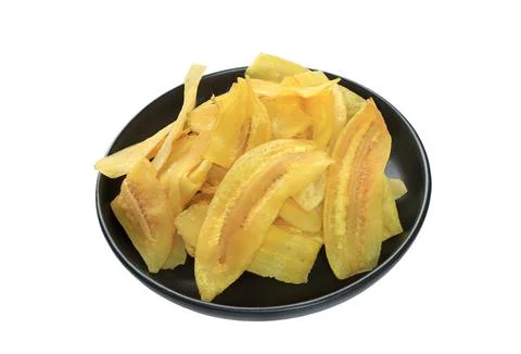 Crispy banana slice chips, fried or baked slice banana on black plate Stock Photos