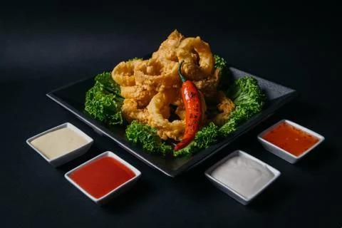 Crispy battered onion rings with sauces and chilli pepper Stock Photos