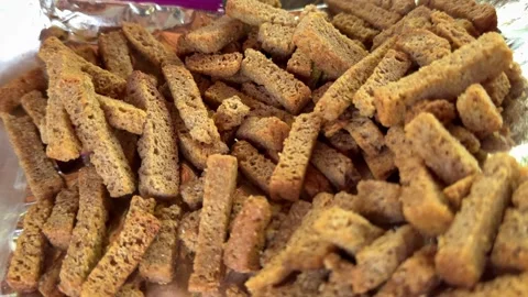 Crispy black bread croutons cut into thin strips on foil with crunchy texture Stock Footage 345725812
