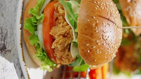 Crispy, breaded chicken double burgers with vegetables and drink, served with Stock Footage 250158130