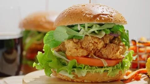 Crispy, breaded chicken double burgers with vegetables and drink, served with Stock Footage 250158220
