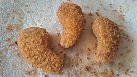Crispy breaded chicken nuggets. Fried golden poultry snacks on a paper towel. Stock Photos