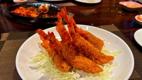 Crispy breaded shrimp served on shredded cabbage in a white bowl, capturing a Stock Footage 333889818