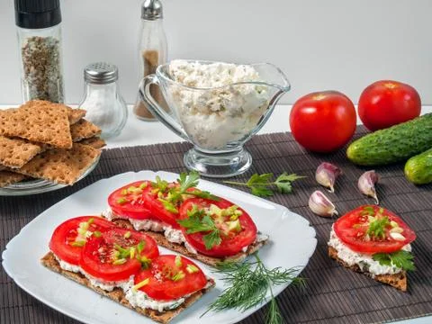 Crispy buckwheat bread with tomatoes, creative cheese, greens Stock Photos