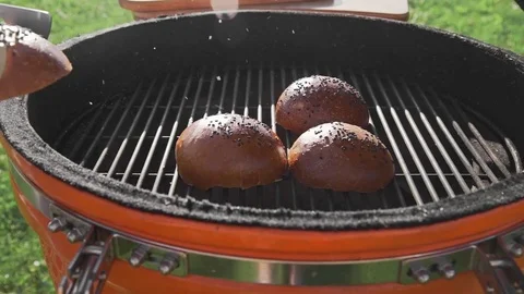 Crispy buns are roasting on the grill in the sunny summer day, cooking food on Stock Footage 77517585