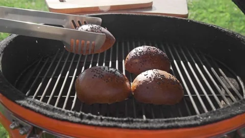 Crispy buns are roasting on the grill in the sunny summer day Stock Footage 143782710