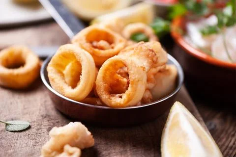 Crispy calamari rings on a rustic table Stock Photos