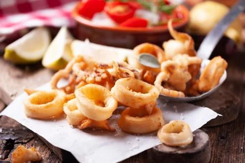 Crispy calamari rings on a rustic table Foto stock