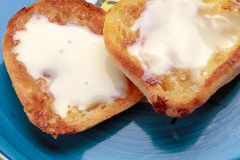 Crispy cheese bread made in skillet covered with creamy cheese. Stock Photos