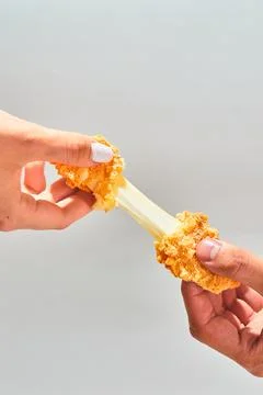 Crispy cheese fried breaded mozzarella cheese sticks stretch two hands Stock Photos
