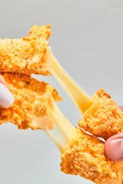 Crispy cheese fried breaded mozzarella cheese sticks stretch two hands Stock Photos