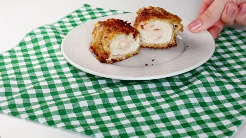 Crispy chicken cordon bleu served on white plate. Golden breaded exterior Stock Footage 283727041