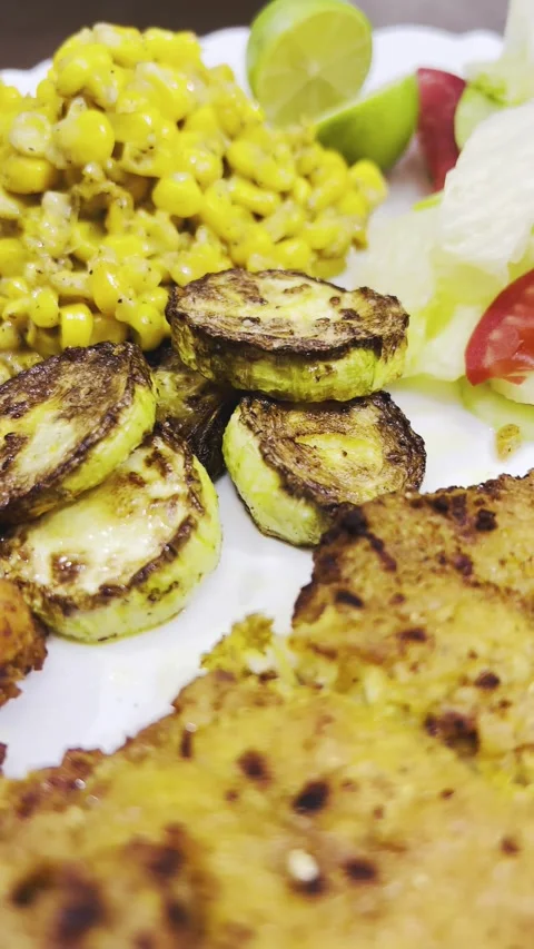Crispy chicken cutlet close-up with grilled zucchini and corn, vertical shot Stock Footage 345166306