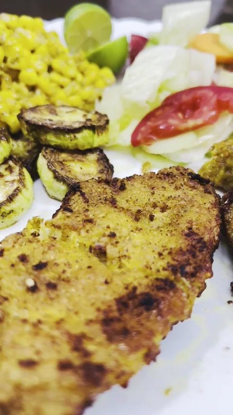 Crispy chicken cutlet close-up with grilled zucchini and corn, vertical shot Stock Footage 345166384