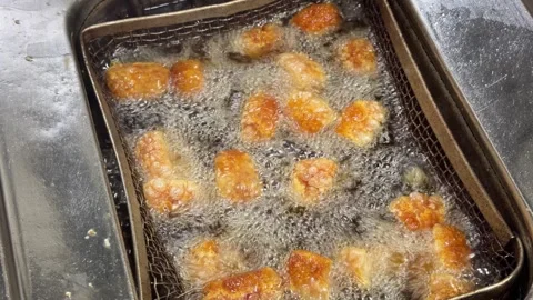 Crispy chicken pieces deep frying in boiling oil 動画素材 344100214