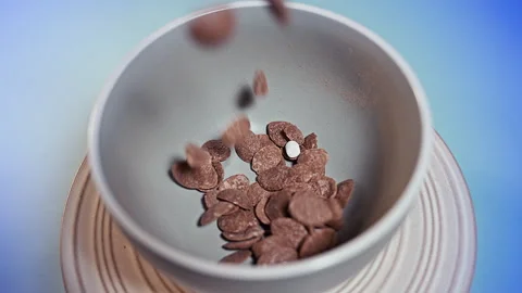 Crispy Chocolate Cereal Flakes with White Marshmallows Falling into a Bowl Stock Footage 341962906