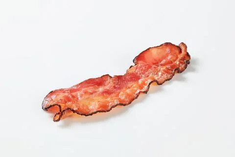 Crispy cooked bacon strip on clean surface Stock Photos