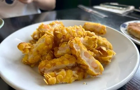Crispy Corn-Coated Chicken Strips on a White Plate Stock Photos