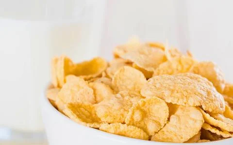 Crispy corn flakes cereal in a white bowl with milk Stock Photos