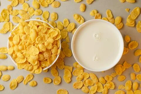 Crispy corn flakes served with fresh milk on a rustic table spread Stock Photos