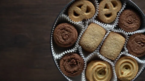Crispy crumbly shortbread cookies in round metal box on wooden table, rotates 動画素材 331537005