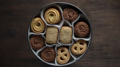 Crispy crumbly shortbread cookies in round metal box on wooden table, rotates Video stock 333688006