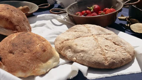 Crispy crust homemade bread of medieval peasants in village camp, traditional Stock Footage 241687155