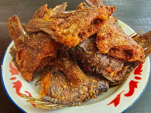 Crispy Deep Fried Whole Fish on Traditional Spicy Indonesian Seasoning Фото
