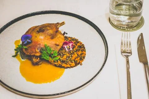 Crispy Duck Confit: Depth, Richness, and Control Served with a spicy lentil.. Stock Photos