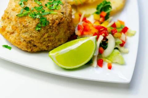 Crispy fish cake with fresh herbs and tropical salsa Stock Photos