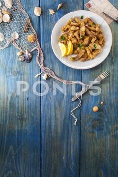 Crispy Fish Fingers On A Blue Wooden Surface With Maritime Decorations