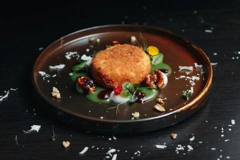 Crispy fried appetizer artfully plated, surrounded by fresh herbs Stock-Fotos