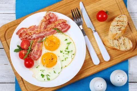 Crispy fried bacon and eggs on plate Stock Photos