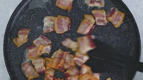 Crispy fried bacon slices on a frying pan close-up. English breakfast recipe Stock Footage 225807152