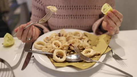 Crispy fried calamari with fresh lemon on a plate Stock Footage 327809536