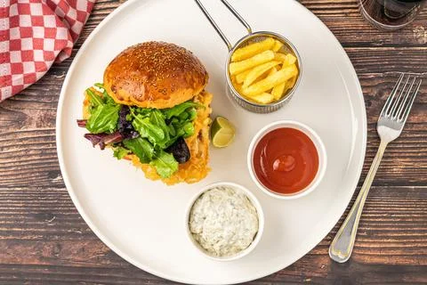 Crispy fried chicken burger served with fries and creamy dips Stock Photos