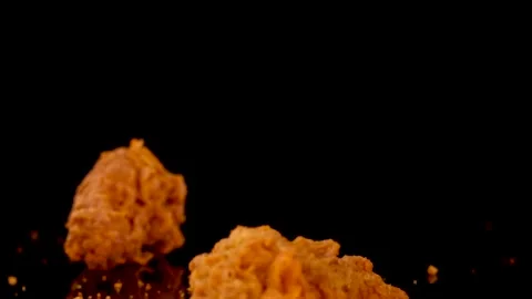 Crispy Fried Chicken Pieces Dropping Onto Black Surface Stock Footage 314086560