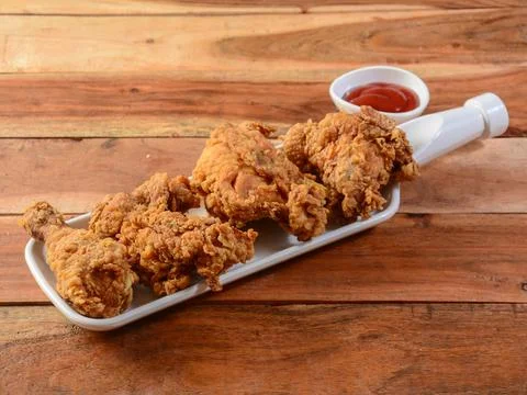 Crispy fried chicken served on rustic wooden background. Dishes and appetizer Stock Photos