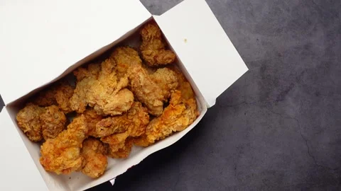 Crispy fried chicken wings in a paper packet on black Stock Footage 202135239