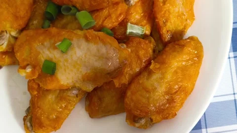 Crispy fried chicken wings sizzling on a plate, ready to be devoured with fresh  Video stock 318253271